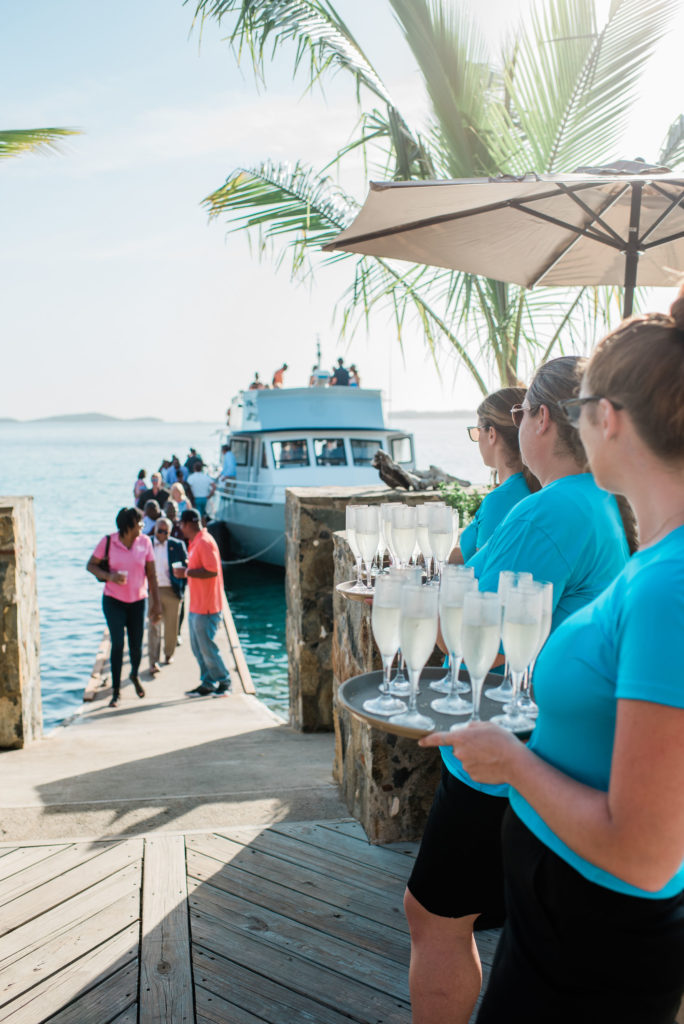 A group of servers holding drinks near the dock