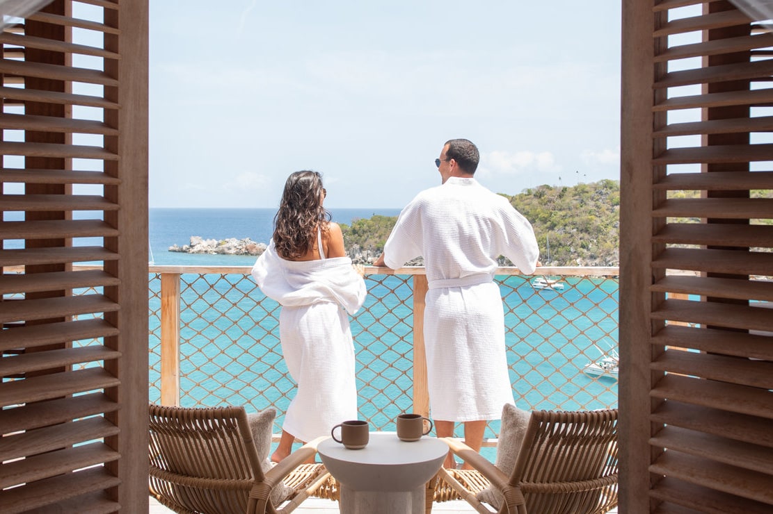 couple standing on balcony looking at ocean lovango