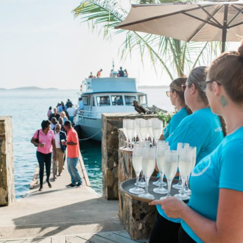 Servers holding drinks near the dock