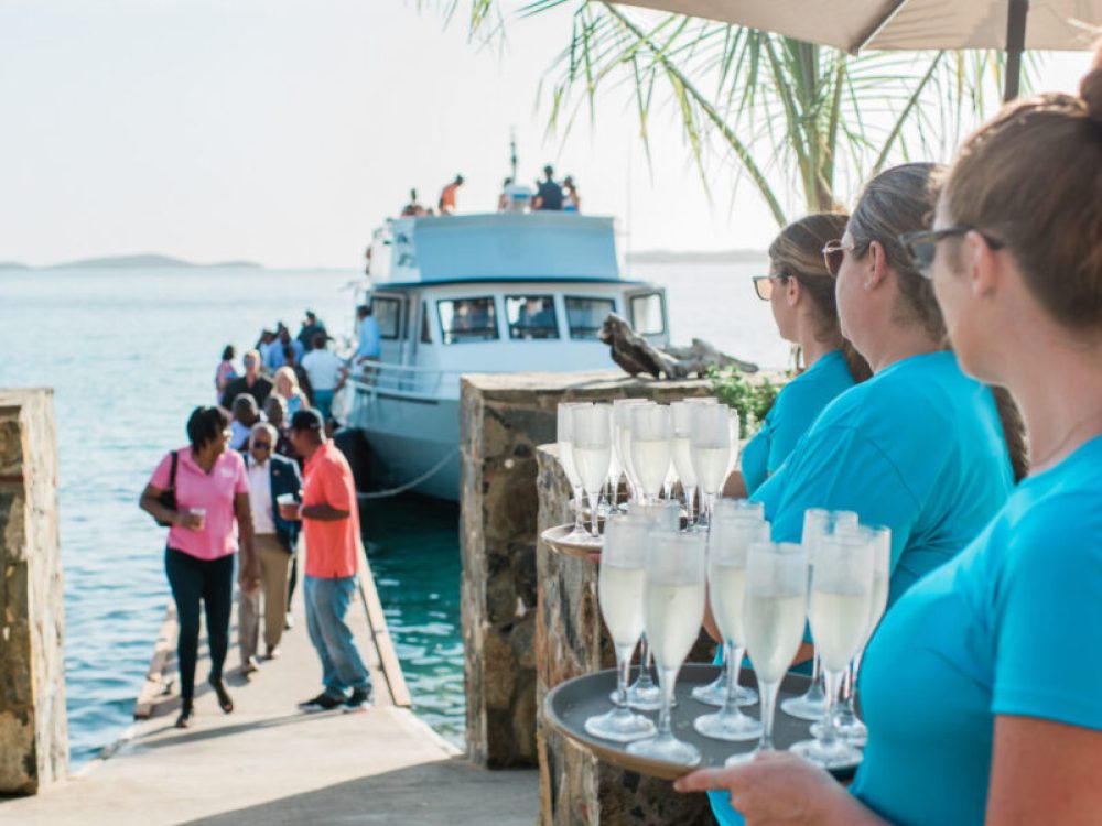 A group of servers holding drinks near the dock